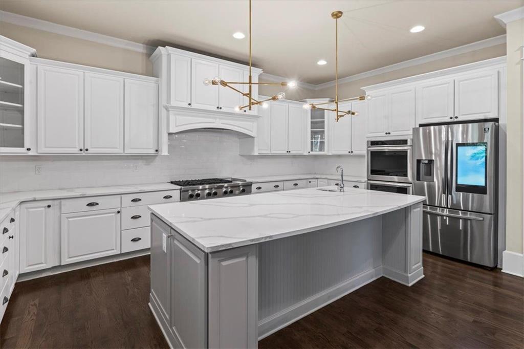2996 Cambridge Hill Drive Dacula, GA 30019 - Photo 19 of 49 a kitchen with stainless steel appliances granite countertop a white stove top oven a refrigerator a oven and white cabinets with wooden floor