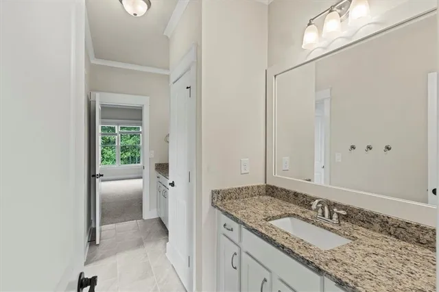 a en suite bathroom with a granite countertop sink and a mirror