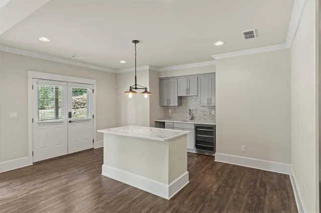 a kitchen with a sink a stove cabinets and wooden floor