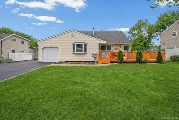 a front view of house with yard and trees in the background