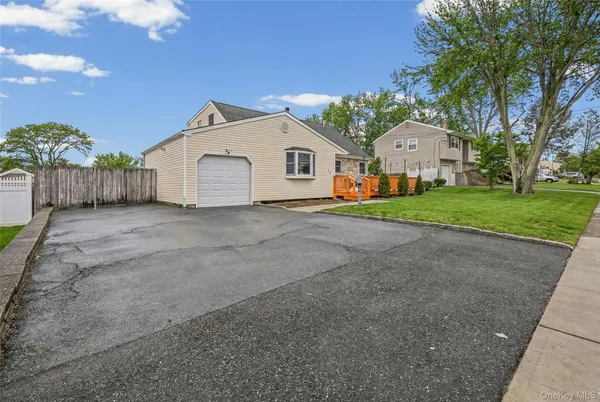 a view of a house with a yard and large tree