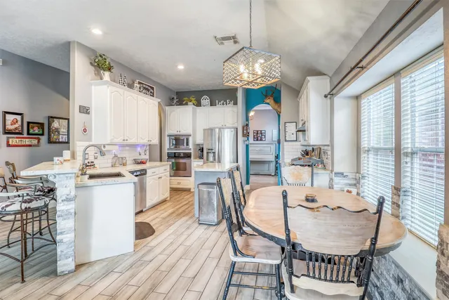 a view of a dining room with furniture a chandelier and wooden floor