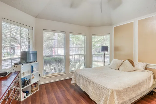 a bedroom with a bed and a flat tv screen on the dresser