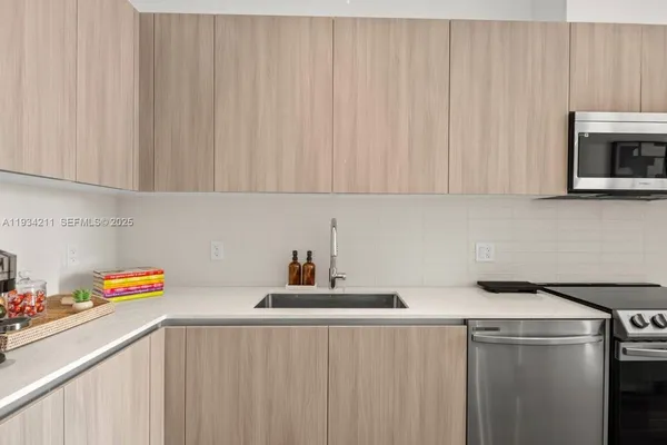 a kitchen with sink refrigerator dining table and chairs