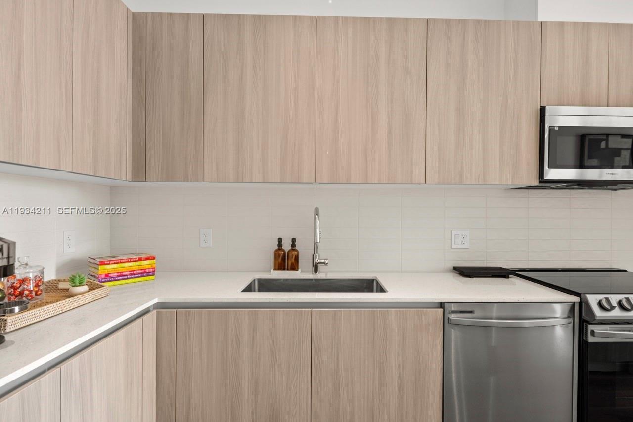 2800 Southwest 27th Terrace, Unit 1918 Miami, FL 33133 - Photo 3 of 15 a kitchen with a sink cabinets and stainless steel appliances
