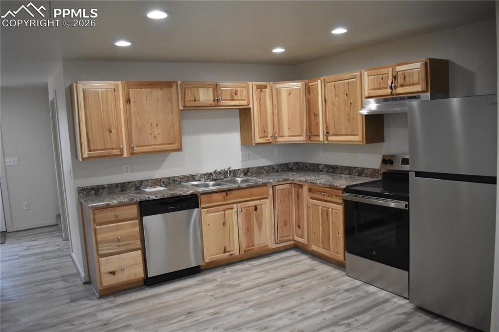 805 Raton Avenue La Junta, CO 81050 - Photo 7 of 26 a kitchen with stainless steel appliances granite countertop a stove a sink and a refrigerator