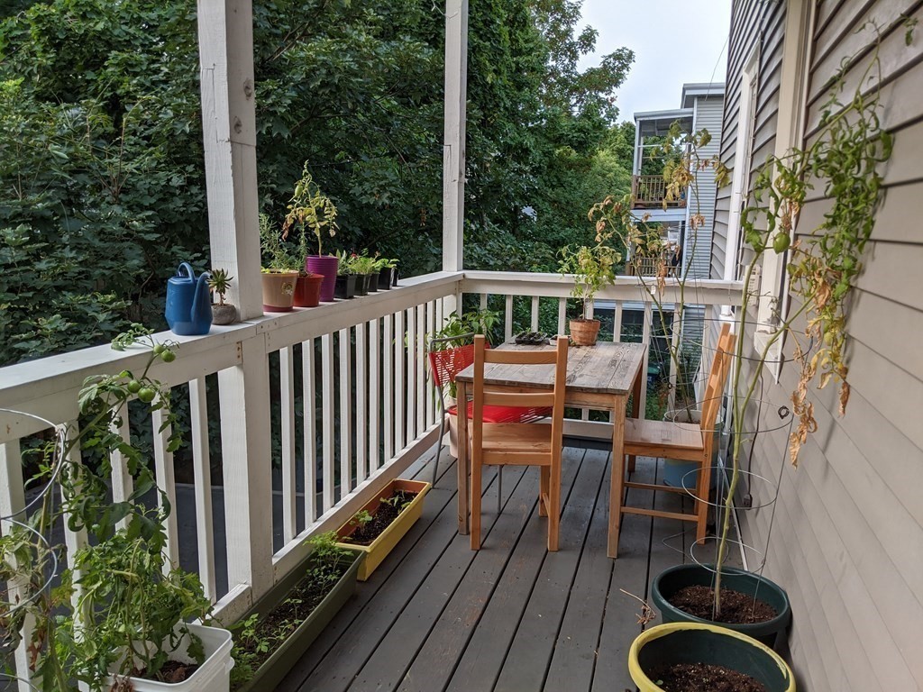 a view of balcony with wooden floor and seating space