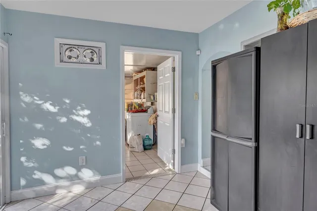 a view of a refrigerator in kitchen and an empty room