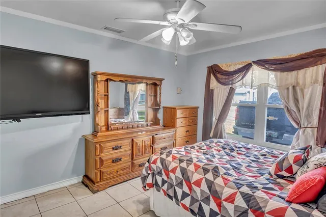 a bedroom with a bed and a flat tv screen on the dresser