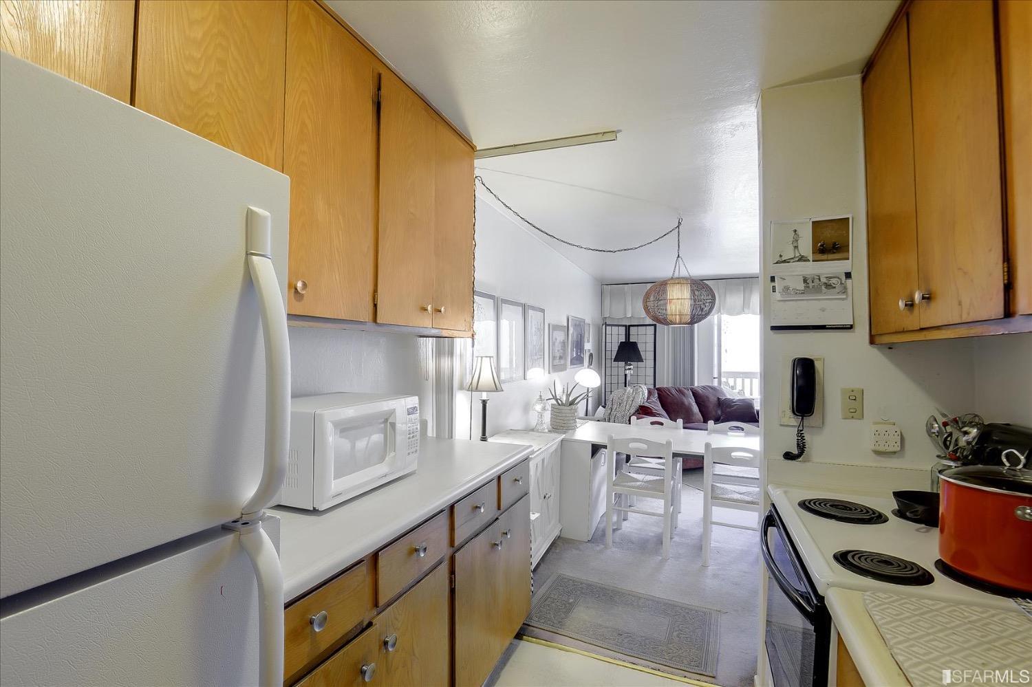 50 Inca Lane, Unit 5 San Francisco, CA 94115 - Photo 7 of 33 a kitchen with a sink dishwasher a stove and a refrigerator with wooden cabinets