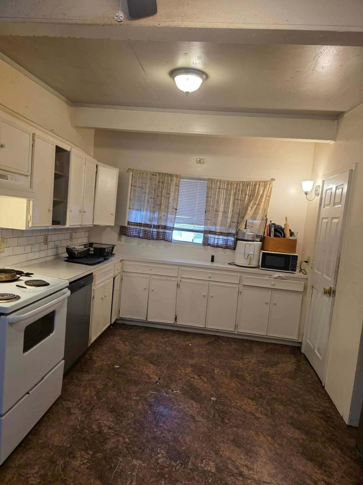 2304 48th Street Lubbock, TX 79412 - Photo 5 of 5 a kitchen with granite countertop a sink and white cabinets