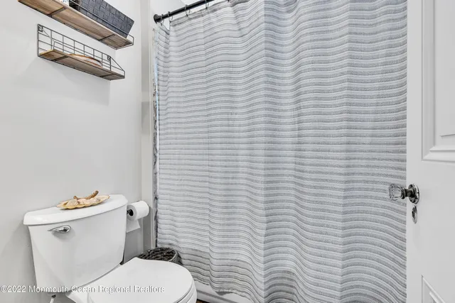 a white toilet sitting next to a white wall