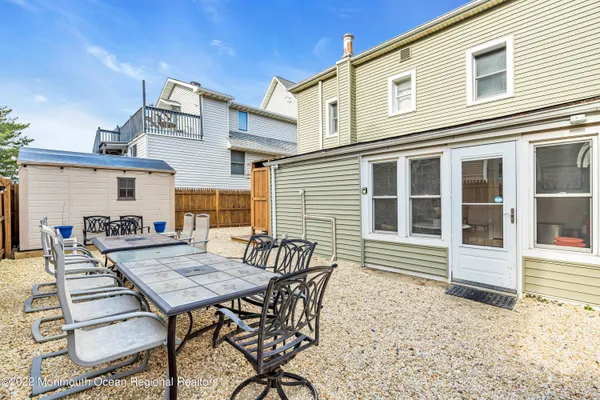 a view of a house with backyard and sitting area