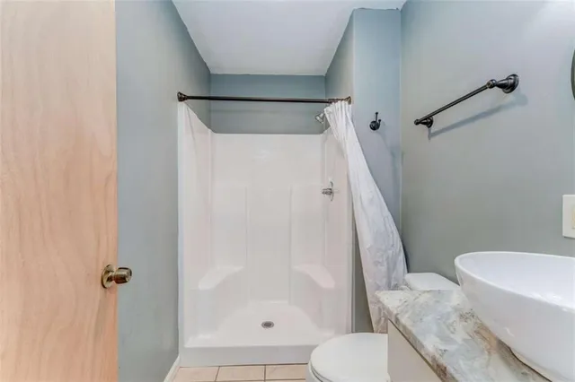 a white toilet sitting next to a shower