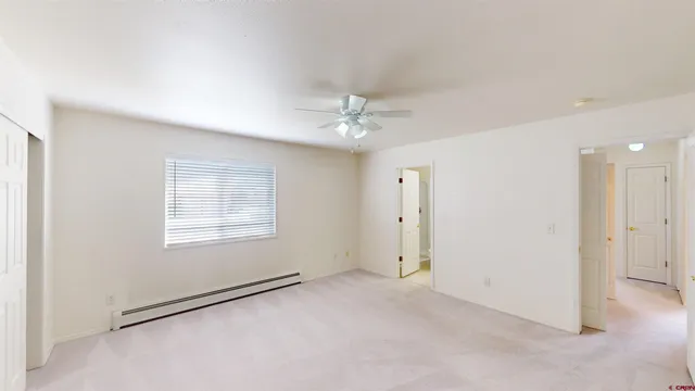 an empty room with closet and fan
