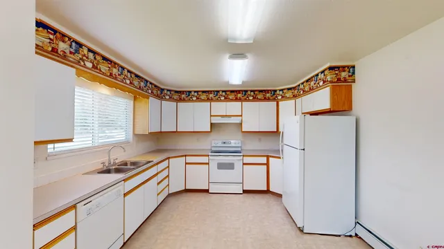 a kitchen with stainless steel appliances granite countertop a sink a stove and a refrigerator