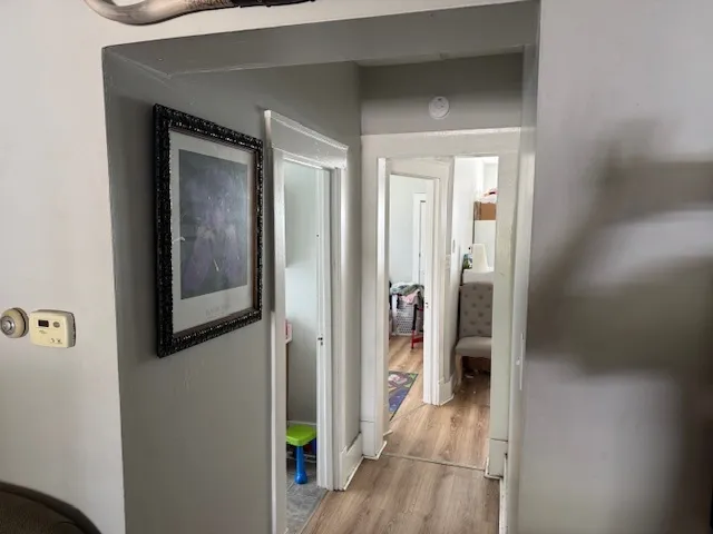 a view of hallway with livingroom and wooden floor
