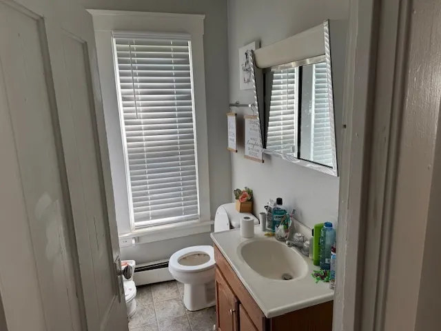 a bathroom with a sink a toilet and a window