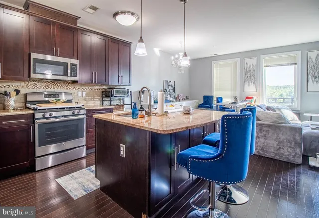 a kitchen with a dining table chairs stainless steel appliances and cabinets