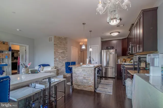 a living room with kitchen island furniture and a chandelier