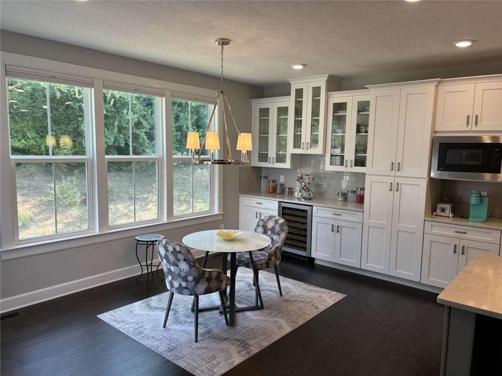 102 Cole Drive McKees Rocks, PA 15136 - Photo 6 of 25 a kitchen with stainless steel appliances kitchen island granite countertop a stove a refrigerator a sink a dining table and chairs with wooden floor