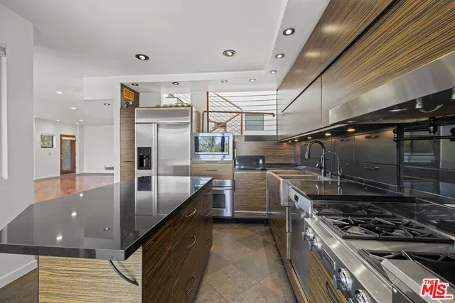 a kitchen with granite countertop a sink and stainless steel appliances