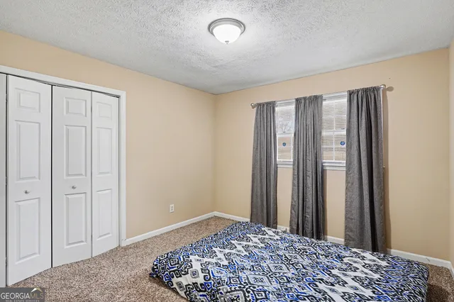 a large bedroom with a bed and wooden floor