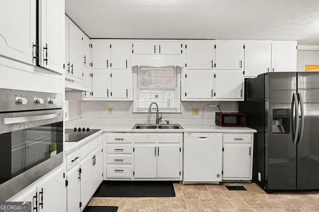 a kitchen with white cabinets and stainless steel appliances