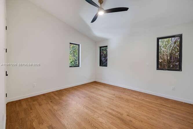 2330 Overbrook Street Coconut Grove, FL 33133 - Photo 44 of 99 an empty room with wooden floor ceiling fan and windows