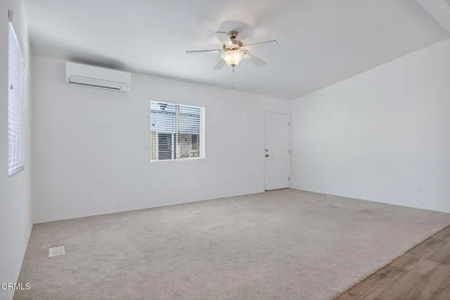 an empty room with a ceiling fan and a window