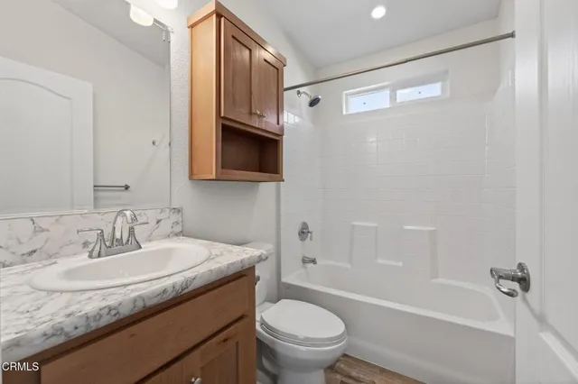 a bathroom with a granite countertop sink toilet and shower