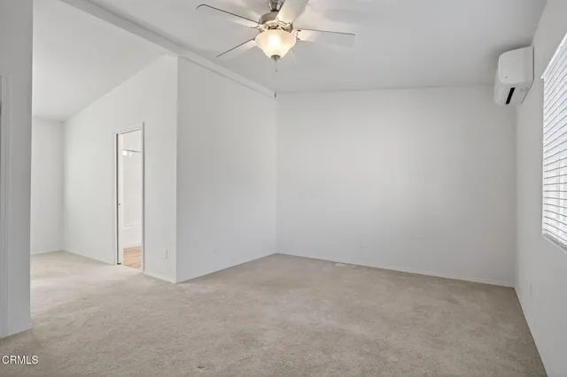 an empty room with a window and a fan