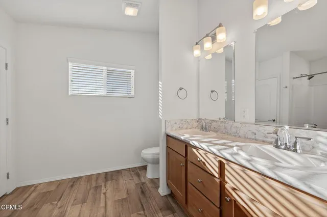 a bathroom with a granite countertop sink a toilet and a mirror