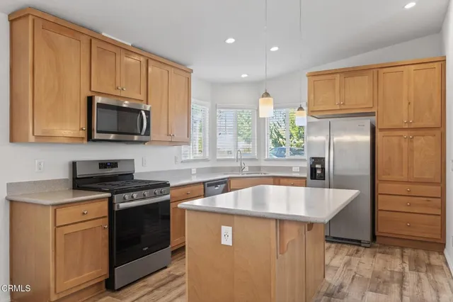 a kitchen with stainless steel appliances granite countertop a sink stove microwave and refrigerator