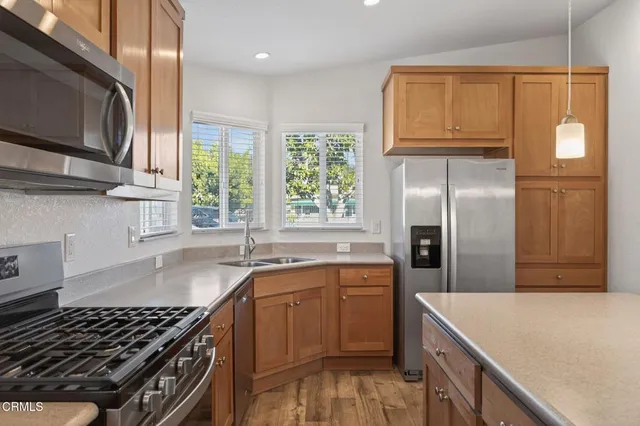 a kitchen with granite countertop a sink stove and refrigerator