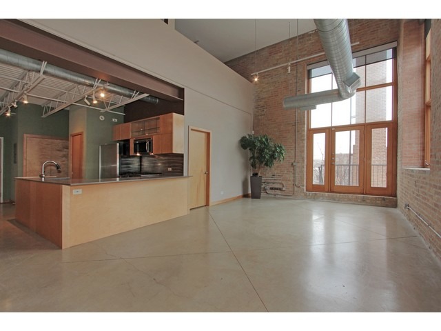 2101 West Rice Street, Unit 301 Chicago, IL 60622 - Photo 2 of 13 a view of an empty room with kitchen and a window