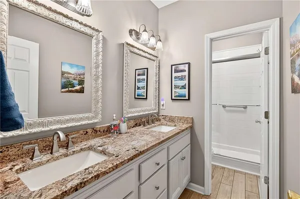 a bathroom with a granite countertop double vanity sink a mirror and