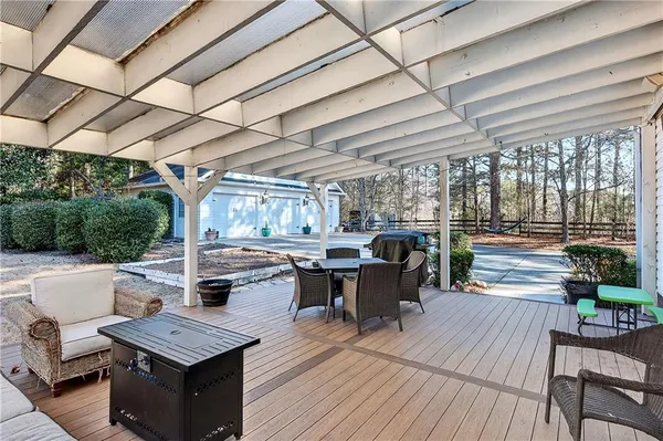 a view of a patio with table and chairs couches with wooden floor and fence