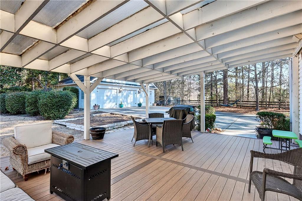 58 Legend Drive Villa Rica, GA 30180 - Photo 22 of 27 a view of a patio with table and chairs couches with wooden floor and fence