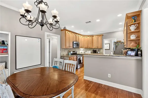 a view of a dining room with furniture a chandelier and wooden floor