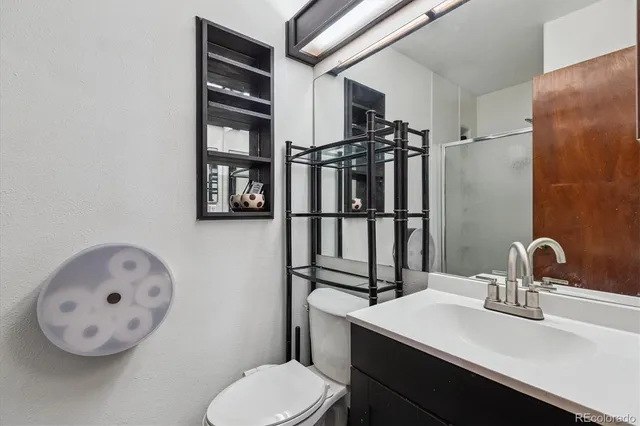 a bathroom with a sink vanity mirror and toilet