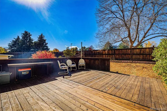a roof deck with table and chairs and wooden floor