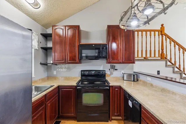 a kitchen with stainless steel appliances granite countertop wooden cabinets a stove top oven a sink and dishwasher