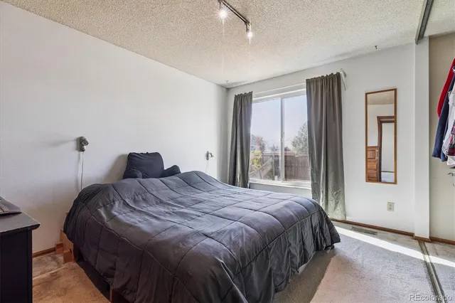 a bedroom with a bed and a large window