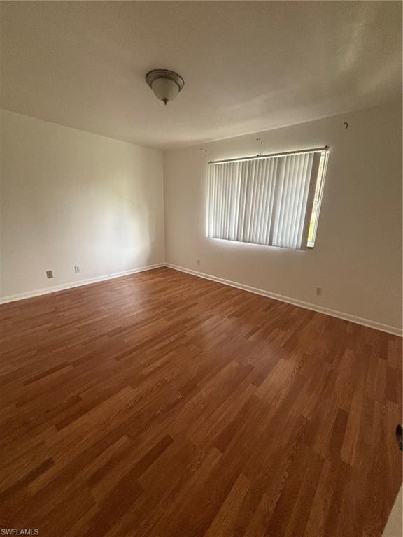5386 16th Place Southwest, Unit F4 Naples, FL 34116 - Photo 6 of 11 wooden floor in an empty room with a window