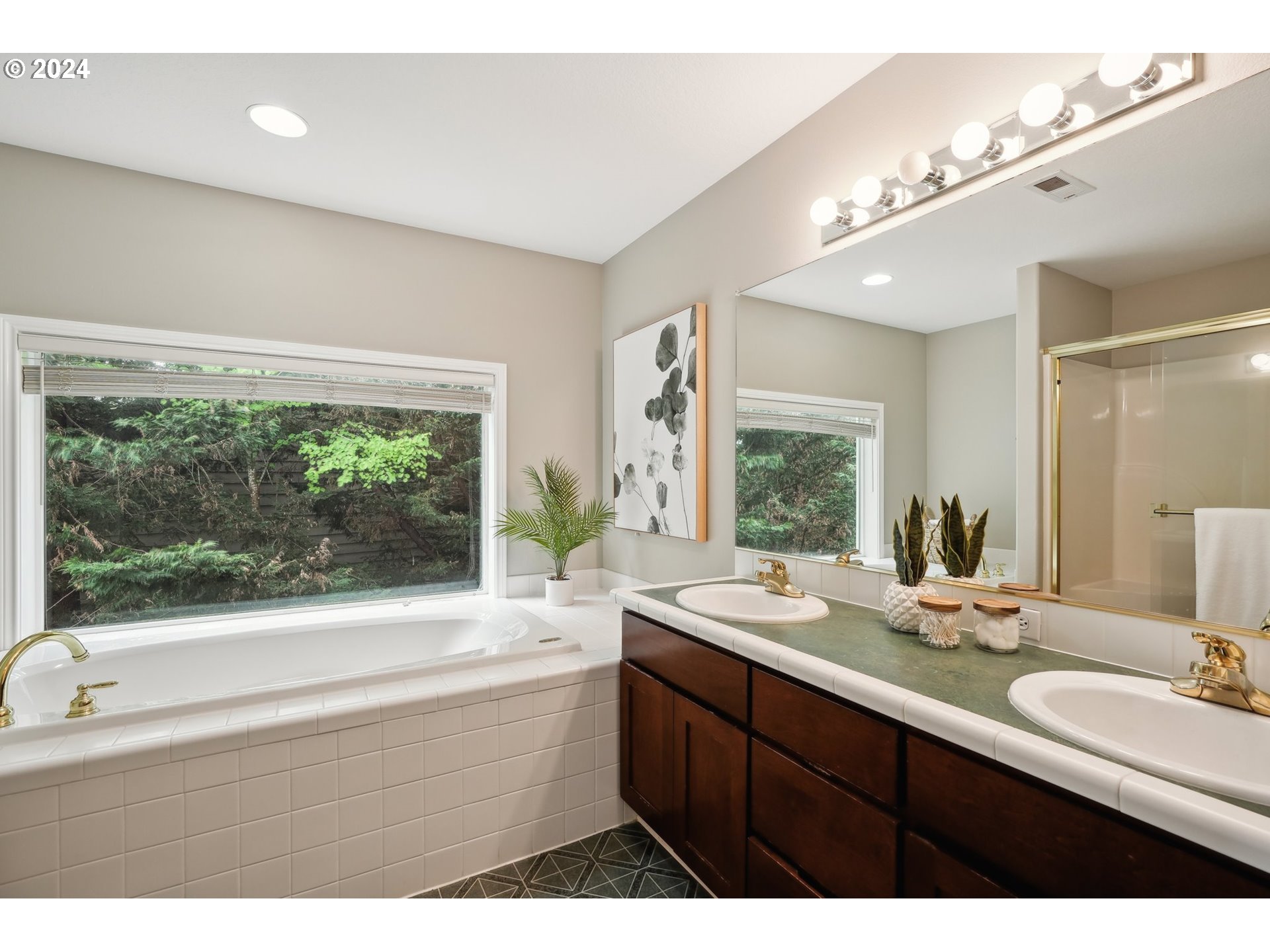 9267 Southwest 83rd Place Portland, OR 97223 - Photo 27 of 44 a bathroom with a double vanity sink a large mirror a bathtub and a large window