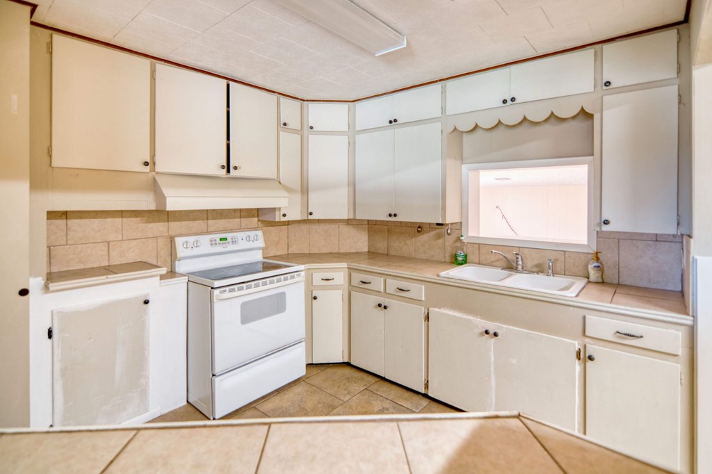511 East Rainey Street Mason, TX 76856 - Photo 11 of 63 a kitchen with a sink cabinets and window