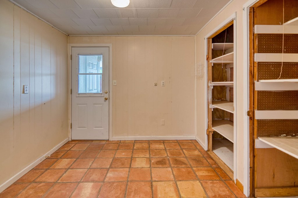 511 East Rainey Street Mason, TX 76856 - Photo 13 of 63 a view of an empty room with wooden floor and cabinets