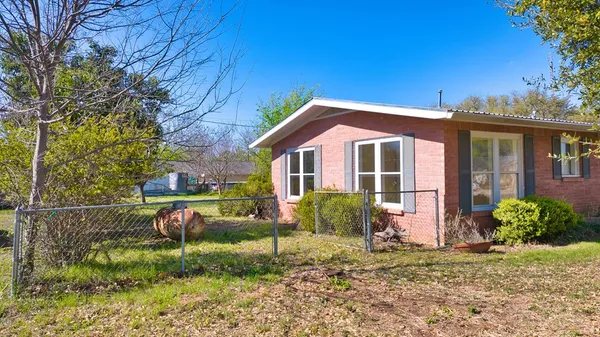 a front view of a house with a yard and potted plants
