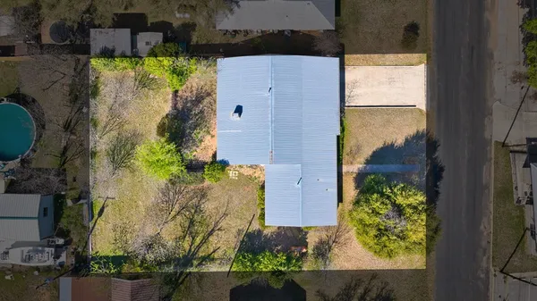 a front view of a house with a yard and potted plants